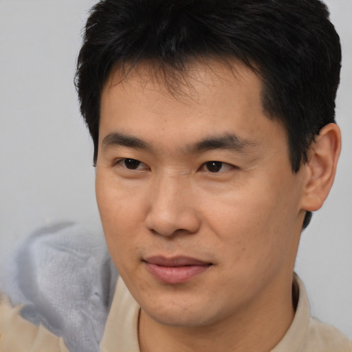 Joyful asian young-adult male with short  brown hair and brown eyes