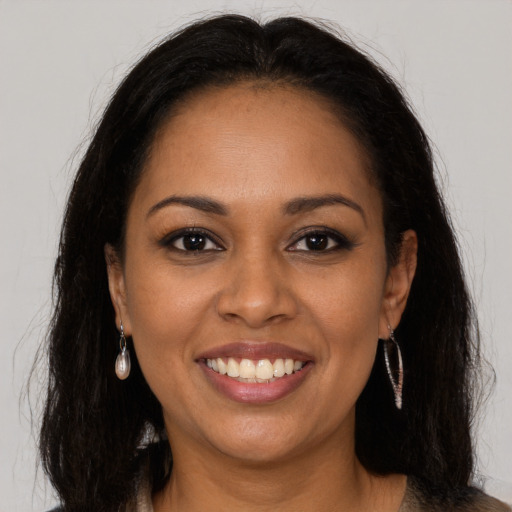 Joyful black young-adult female with long  brown hair and brown eyes