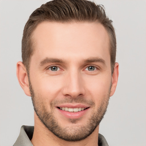 Joyful white young-adult male with short  brown hair and grey eyes