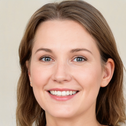 Joyful white young-adult female with long  brown hair and grey eyes