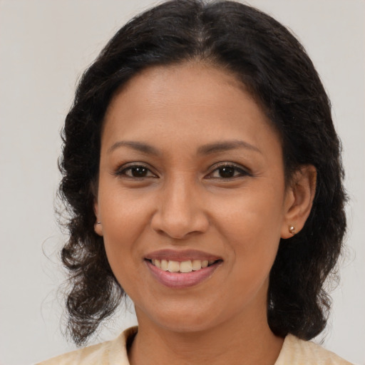 Joyful latino young-adult female with medium  brown hair and brown eyes