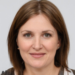 Joyful white adult female with medium  brown hair and grey eyes