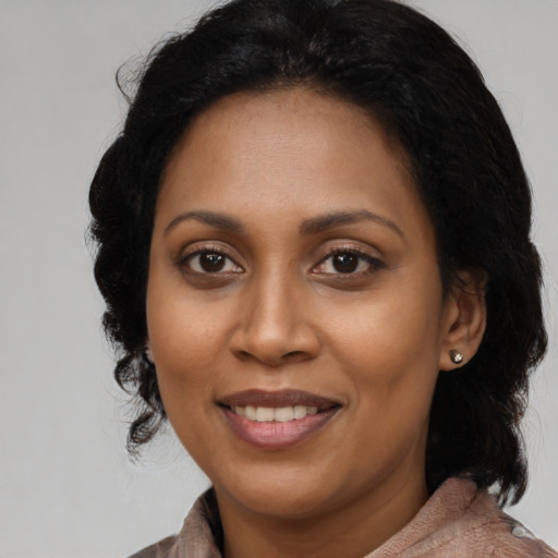 Joyful black adult female with medium  black hair and brown eyes