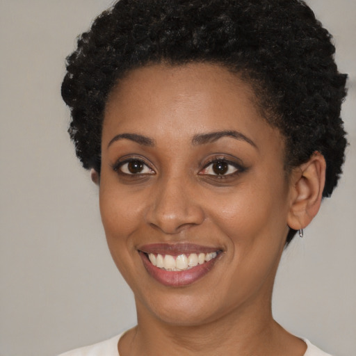 Joyful black young-adult female with short  brown hair and brown eyes