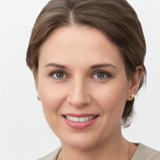 Joyful white young-adult female with medium  brown hair and grey eyes