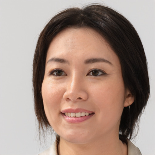 Joyful asian young-adult female with medium  brown hair and brown eyes