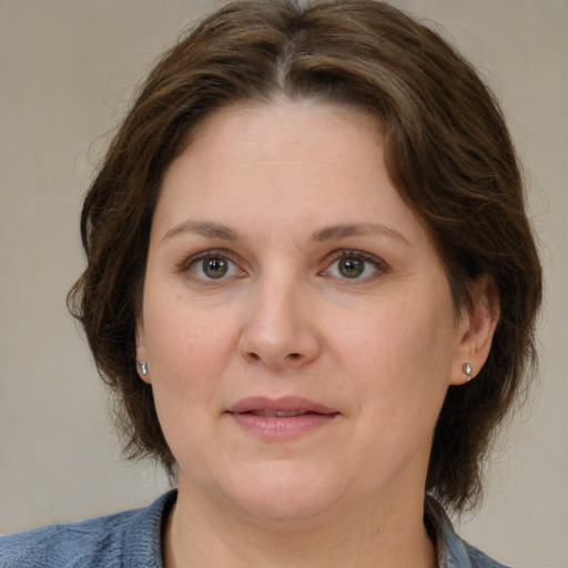 Joyful white adult female with medium  brown hair and grey eyes