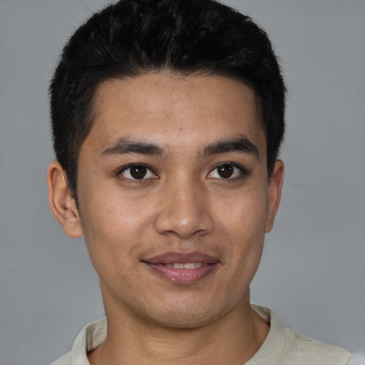 Joyful latino young-adult male with short  black hair and brown eyes