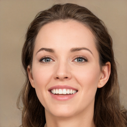 Joyful white young-adult female with long  brown hair and green eyes