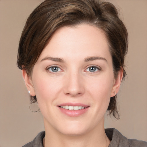 Joyful white young-adult female with medium  brown hair and grey eyes