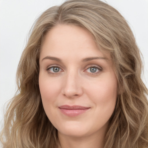 Joyful white young-adult female with long  brown hair and blue eyes