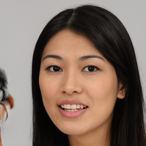 Joyful asian young-adult female with long  black hair and brown eyes