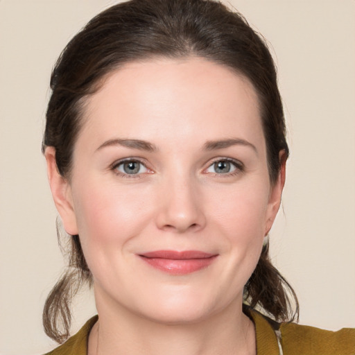 Joyful white young-adult female with medium  brown hair and grey eyes