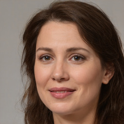 Joyful white adult female with long  brown hair and brown eyes