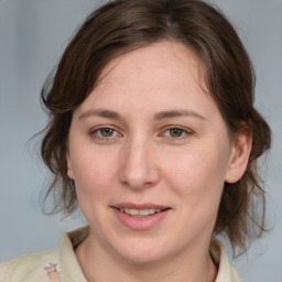 Joyful white young-adult female with medium  brown hair and blue eyes