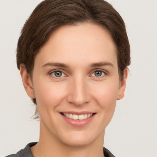 Joyful white young-adult female with short  brown hair and grey eyes