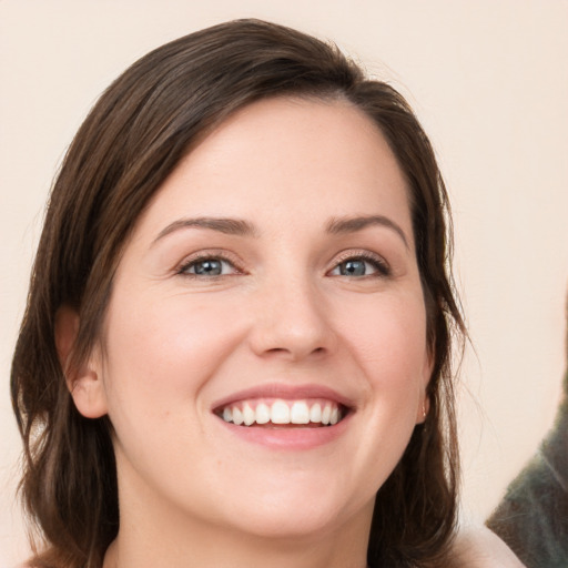 Joyful white young-adult female with medium  brown hair and grey eyes