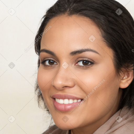 Joyful latino young-adult female with long  brown hair and brown eyes