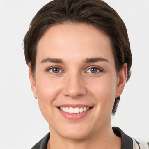 Joyful white young-adult female with short  brown hair and grey eyes