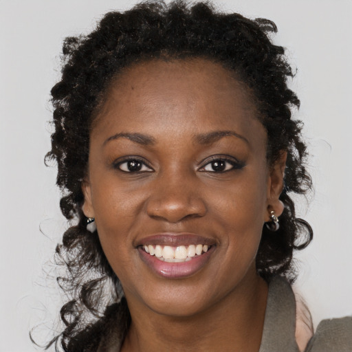 Joyful black young-adult female with long  brown hair and brown eyes