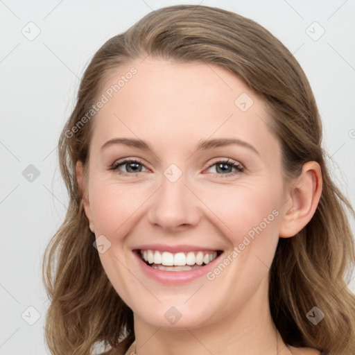 Joyful white young-adult female with long  brown hair and blue eyes