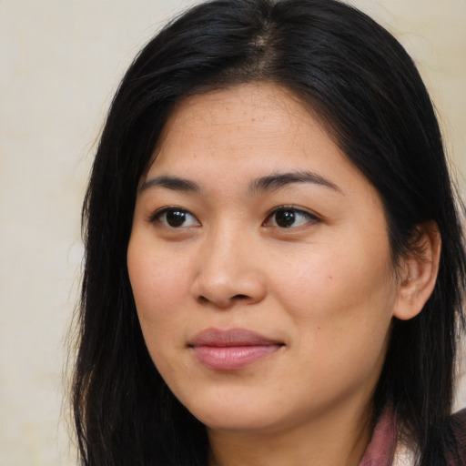 Joyful asian young-adult female with long  brown hair and brown eyes