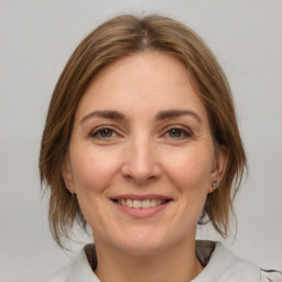 Joyful white adult female with medium  brown hair and brown eyes