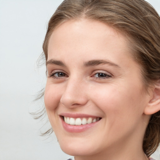 Joyful white young-adult female with medium  brown hair and blue eyes