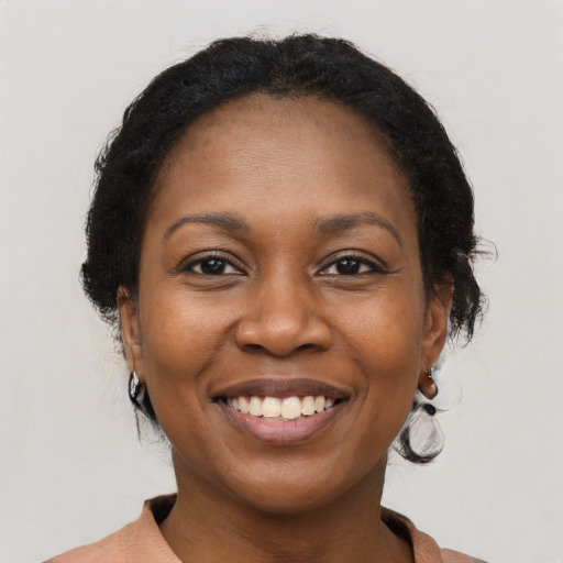Joyful black adult female with long  brown hair and brown eyes