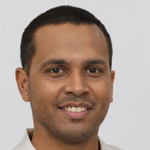 Joyful black young-adult male with short  brown hair and brown eyes