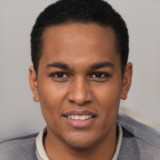 Joyful black young-adult male with short  black hair and brown eyes