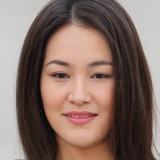 Joyful asian young-adult female with long  brown hair and brown eyes