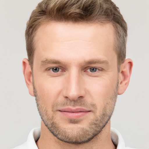 Joyful white young-adult male with short  brown hair and grey eyes