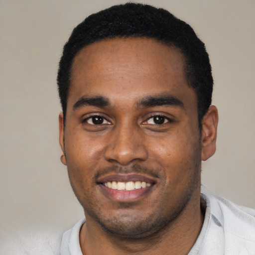 Joyful black young-adult male with short  black hair and brown eyes