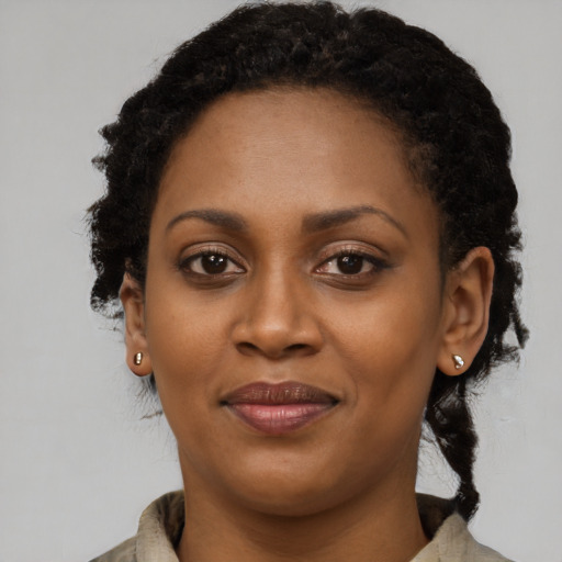 Joyful black young-adult female with short  black hair and brown eyes