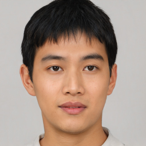 Joyful asian young-adult male with short  brown hair and brown eyes