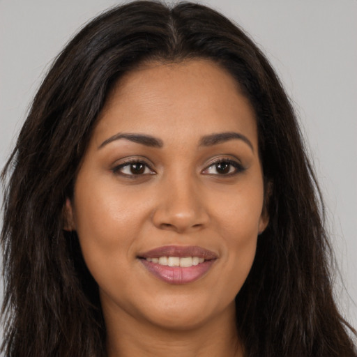 Joyful latino young-adult female with long  brown hair and brown eyes
