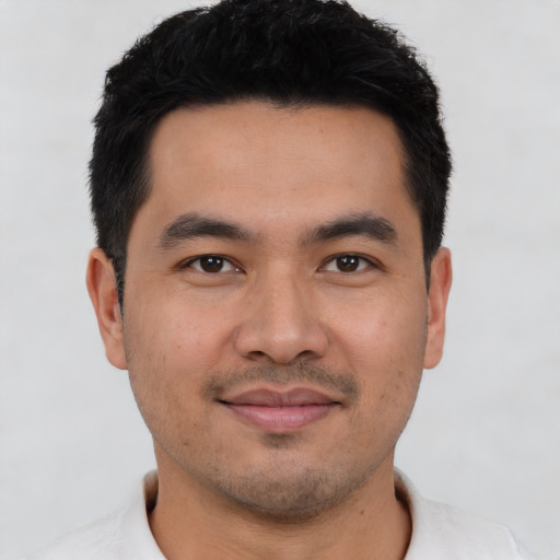 Joyful latino young-adult male with short  black hair and brown eyes