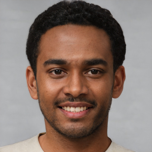 Joyful black young-adult male with short  black hair and brown eyes
