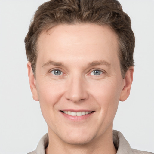 Joyful white adult male with short  brown hair and grey eyes