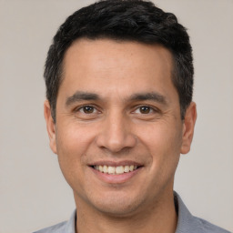 Joyful white young-adult male with short  black hair and brown eyes