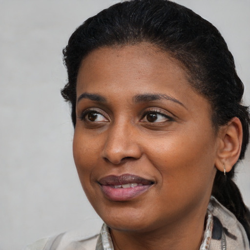Joyful black young-adult female with medium  black hair and brown eyes