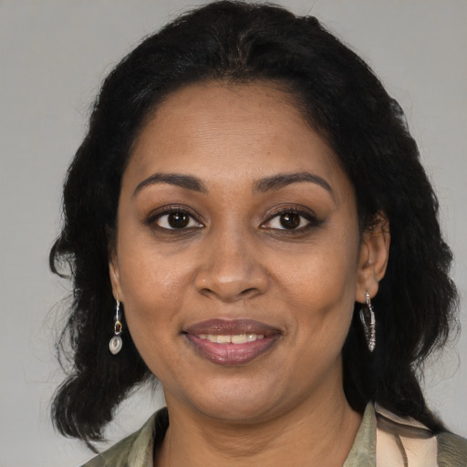 Joyful black adult female with medium  brown hair and brown eyes