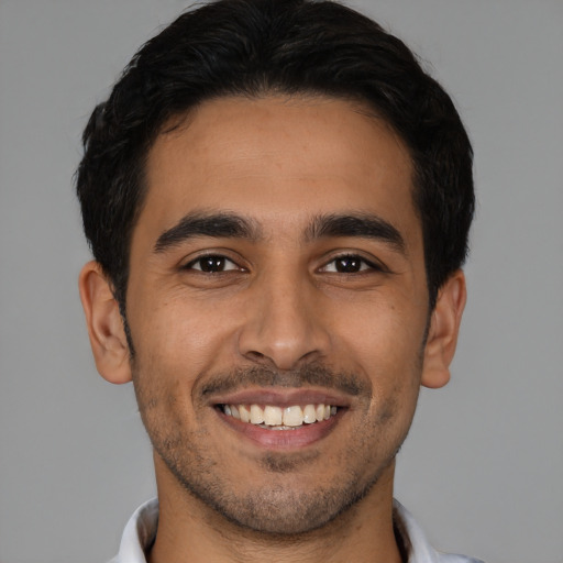 Joyful latino young-adult male with short  black hair and brown eyes