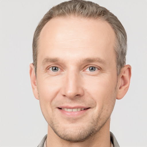 Joyful white adult male with short  brown hair and grey eyes