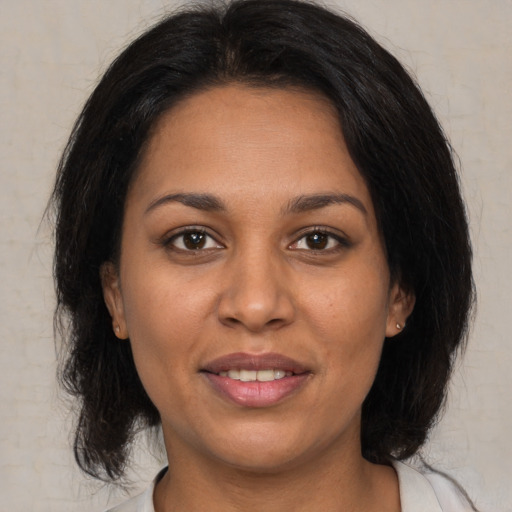 Joyful latino adult female with medium  brown hair and brown eyes