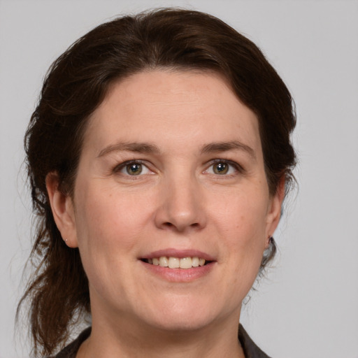 Joyful white adult female with medium  brown hair and grey eyes