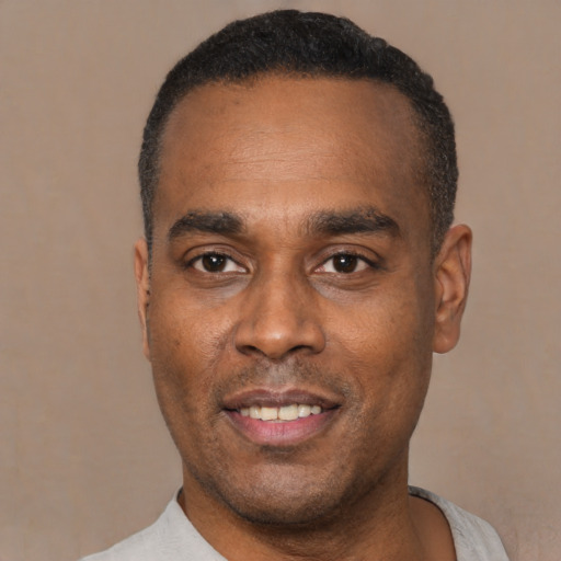 Joyful black young-adult male with short  black hair and brown eyes