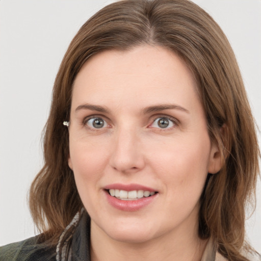 Joyful white young-adult female with medium  brown hair and grey eyes