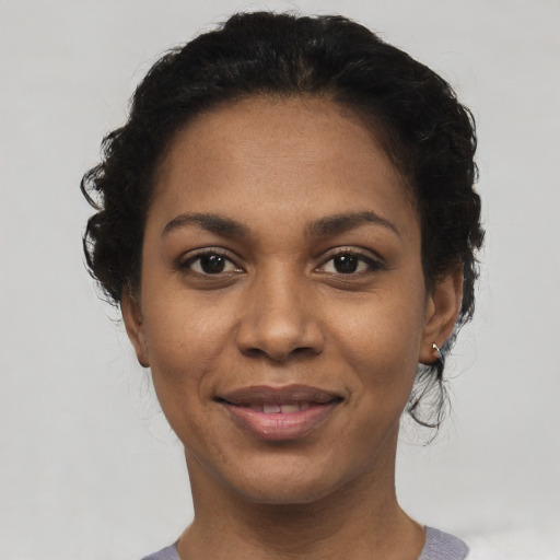 Joyful black young-adult female with short  black hair and brown eyes